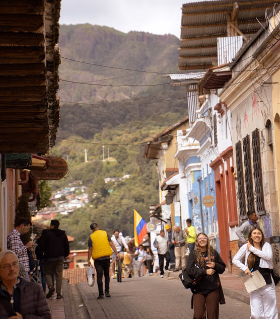 Colorful street in La Candelaria with tourists and the eastern hills in the background.