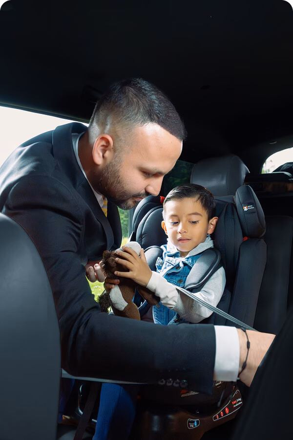 DSC05472 2 Man securing a child in a car seat inside the vehicle.