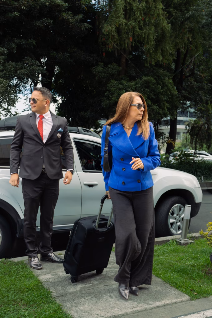 Chauffeur walking two executives with luggage to a private car in Bogota