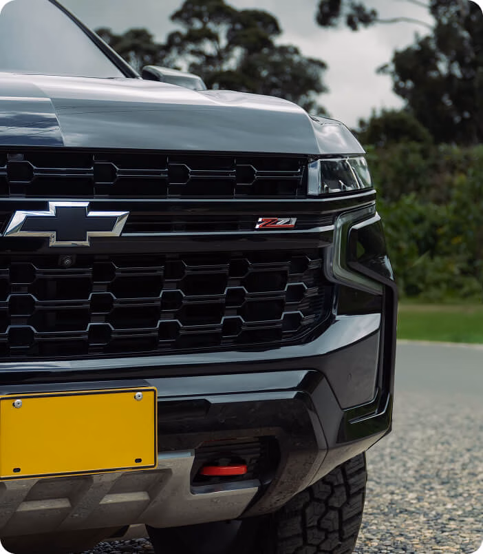 black-chevrolet-tahoe-z71-front-grille-closeup-bowtie-and-z71-badge-yellow-plate-off-road-tires-gravel-cloudy-daytime-img-mobile black-chevrolet-tahoe-z71-front-grille-closeup-bowtie-and-z71-badge-yellow-plate-off-road-tires-gravel-cloudy-daytime-img-mobile