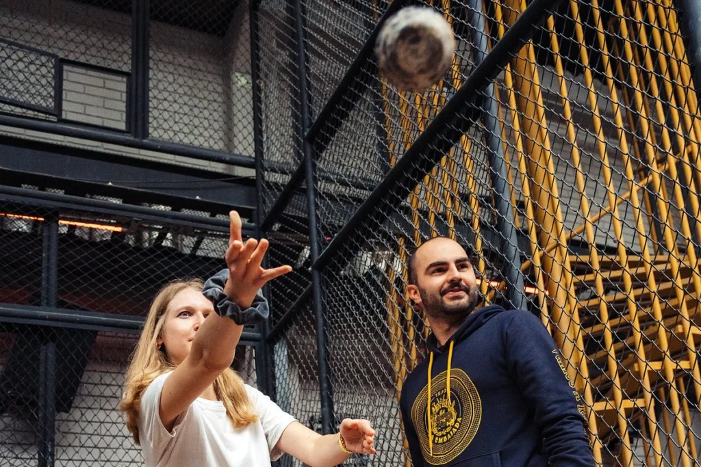 A player releasing a tejo disc toward the clay target inside a caged court in Bogota A player releasing a tejo disc toward the clay target inside a caged court in Bogota