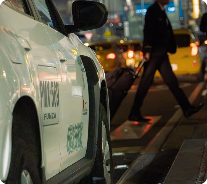 imagen-lista-para-grupo-movil Taxi en la cola del aeropuerto por la noche, con un viajero que camina con su maleta.