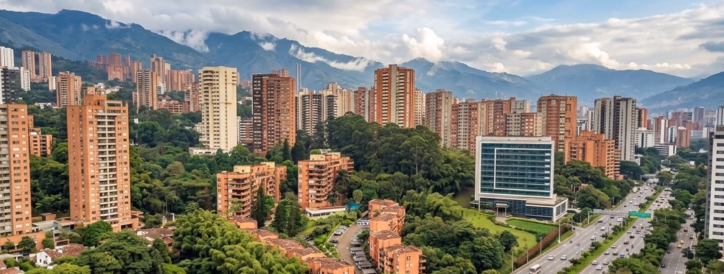 Aerial view of Medellín with residential buildings among green mountains.