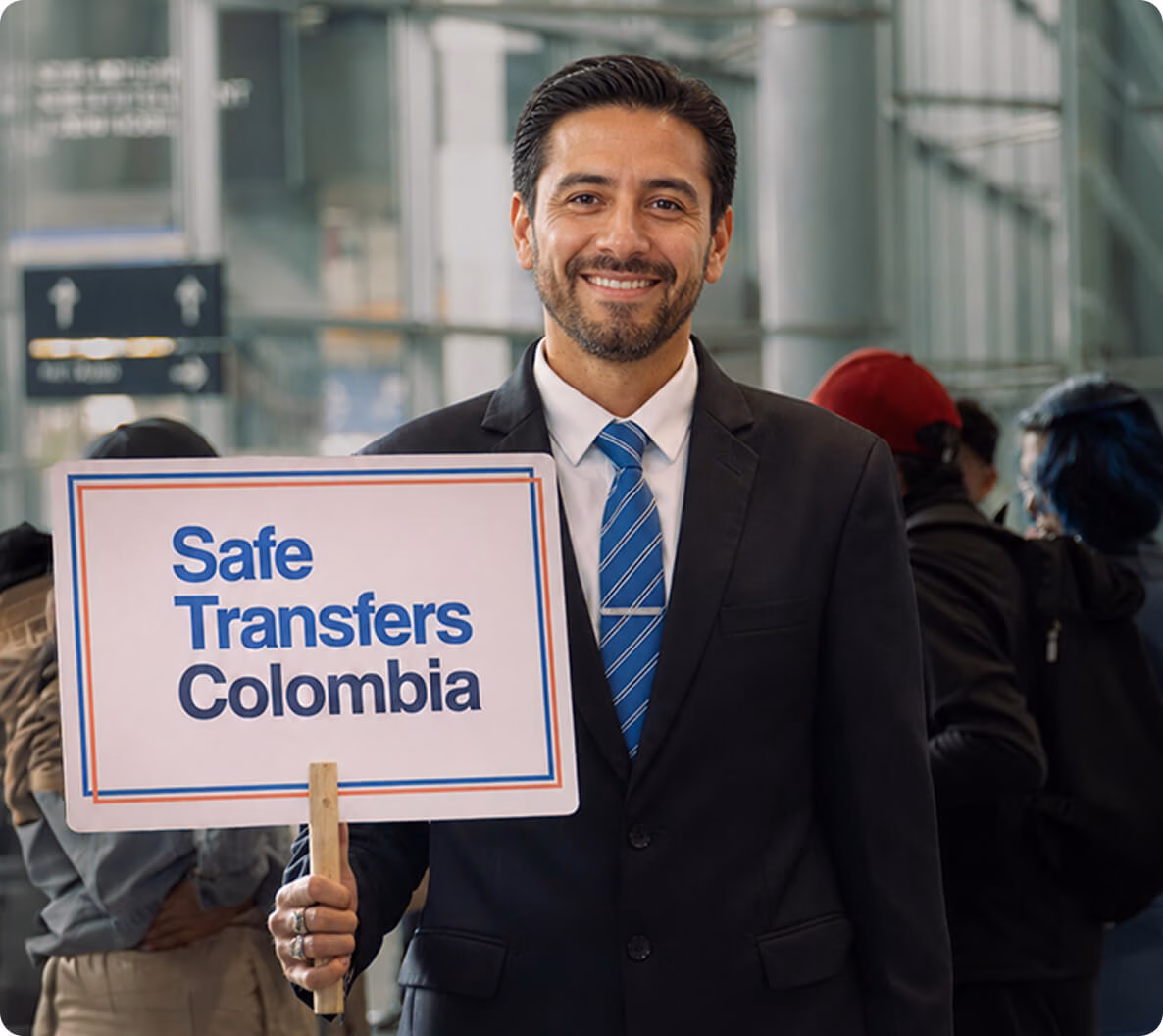 safetransfers-sign-img Tour guide holding a Safe Transfers Colombia sign at the airport.
