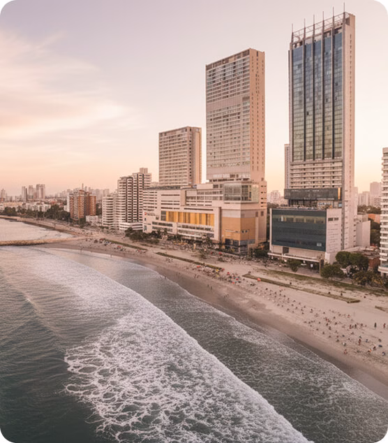 Barranquilla waterfront at sunset, with fishing boats and modern buildings by the water.
