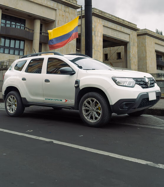 White SUV with a Colombian flag parked in front of a government building.